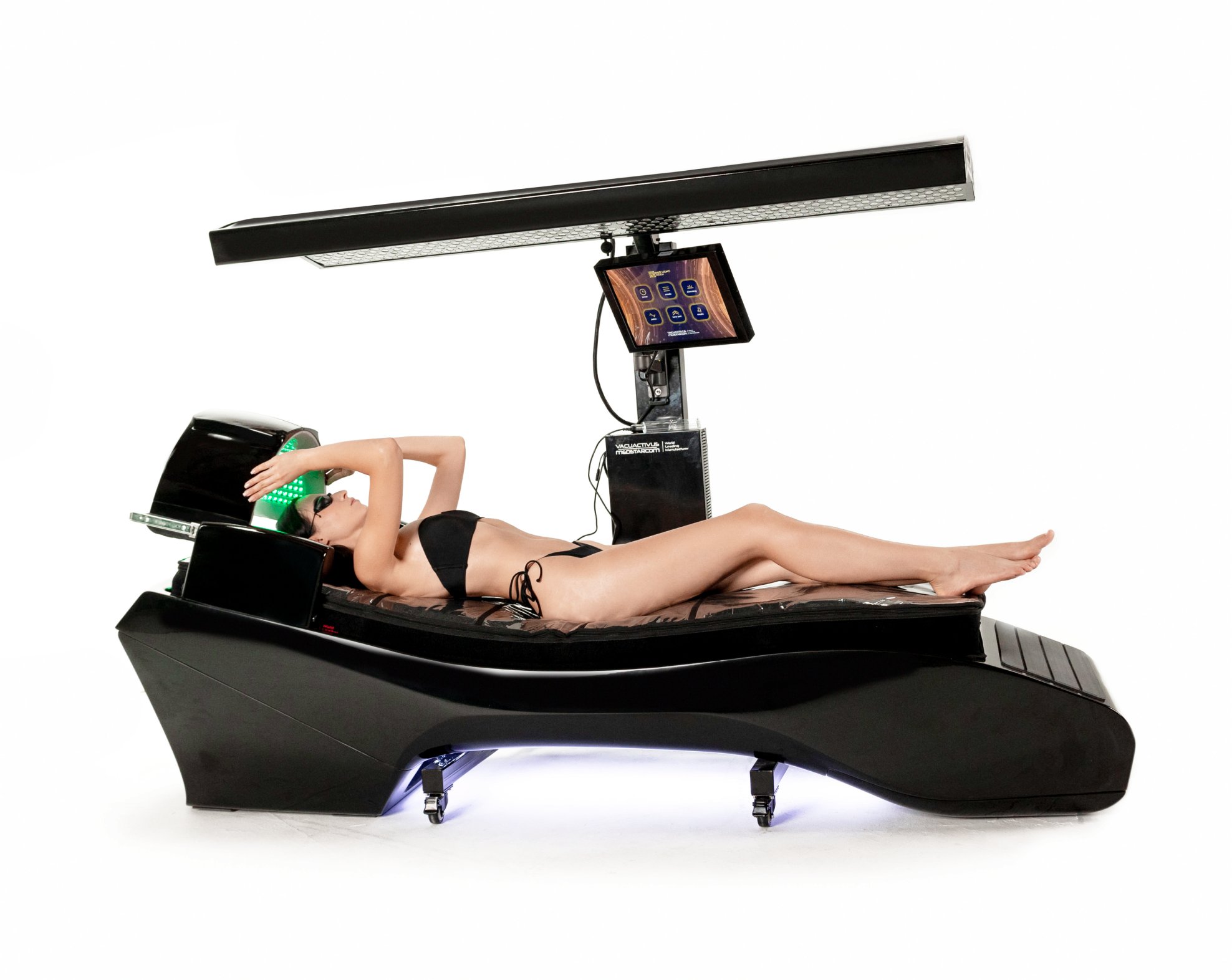 Persoană întinsă pe un solar negru, futurist, cu o lumină/braț deasupra și un controler cu ecran tactil montat deasupra patului, purtând un bikini negru.