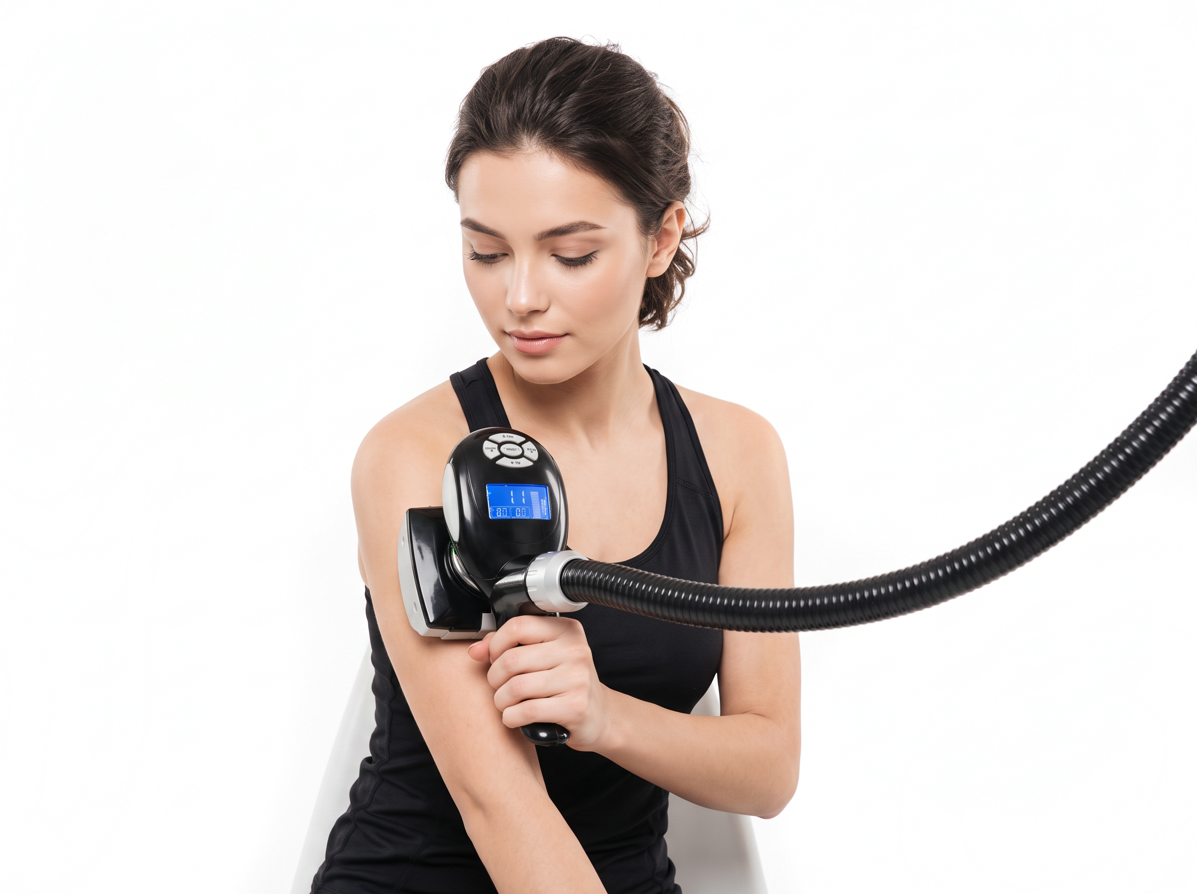 امرأة ترتدي قميصًا رياضيًا أسود تجلس أمام جدار أبيض وتمسك بجهاز تشكيل الجسم Silhouette Shaper المزود بشاشة مضيئة على ذراعها، ويمتد خرطوم أسود طويل مموج إلى اليمين