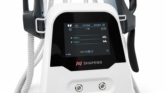 Primo piano del touchscreen del Silhouette Shaper EMS sull'unità bianca, che mostra l'elenco dei modelli di trattamento salvati sopra il logo del prodotto, con i supporti per gli applicatori su entrambi i lati.